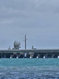 An unclear image featuring a bridge over turquoise waters, lacking identifiable details or subjects.