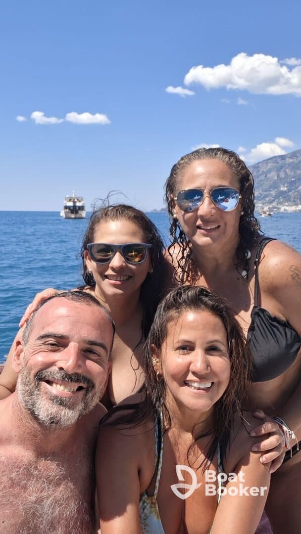 A joyful group of friends poses for a selfie while enjoying a sunny day on the water, capturing the essence of fun and friendship during their boating adventure.