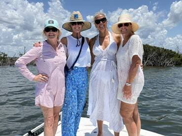 A joyful group of friends poses together on a boat, enjoying a sunny day on the water — perfect for memorable outings and celebrations.