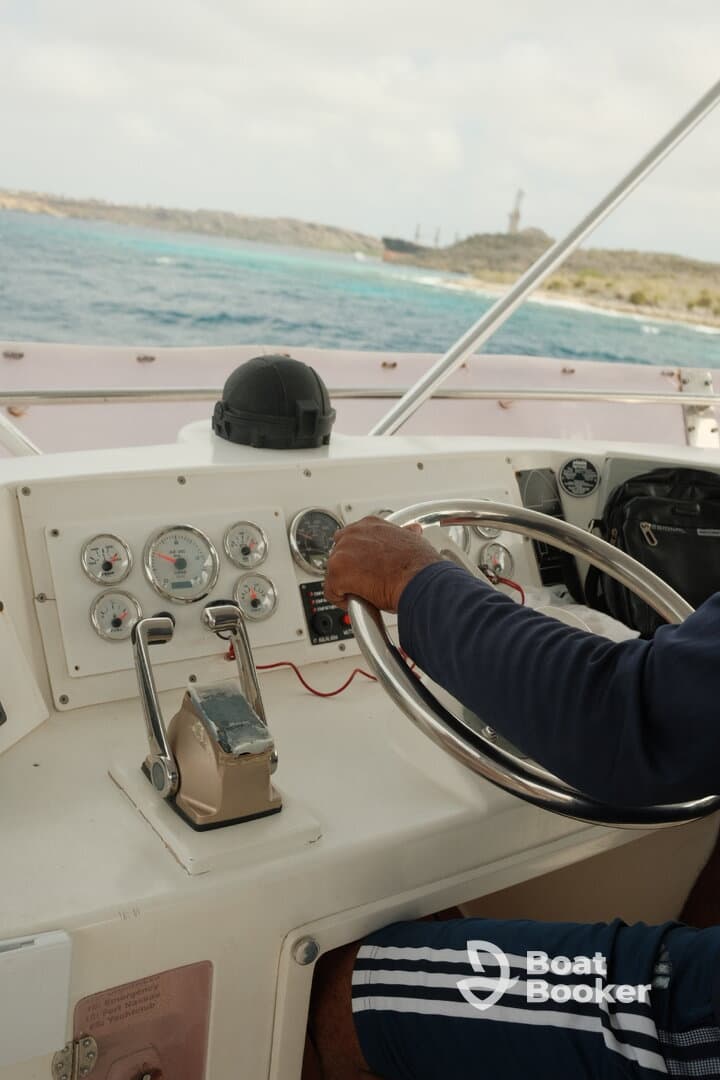 A close-up view of the helm inside a boat, showcasing the steering wheel and control panel, perfect for navigating the open waters.