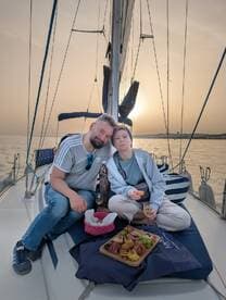 A couple enjoys a romantic sunset on a yacht, sharing a delicious spread of food and drinks — perfect for intimate celebrations on the water.