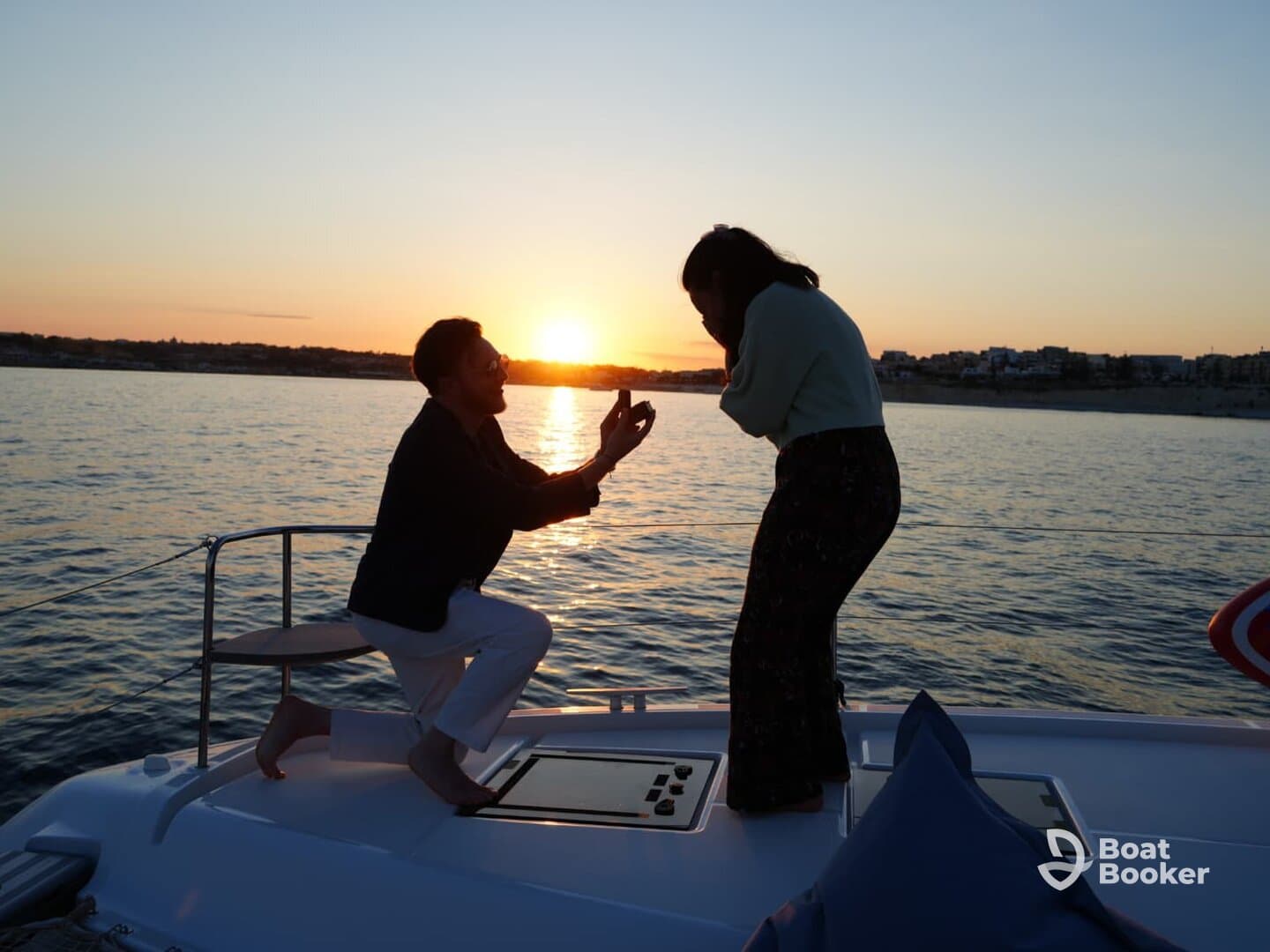A romantic sunset proposal on a yacht captures a couple in a heartfelt moment, making it a perfect backdrop for unforgettable memories.