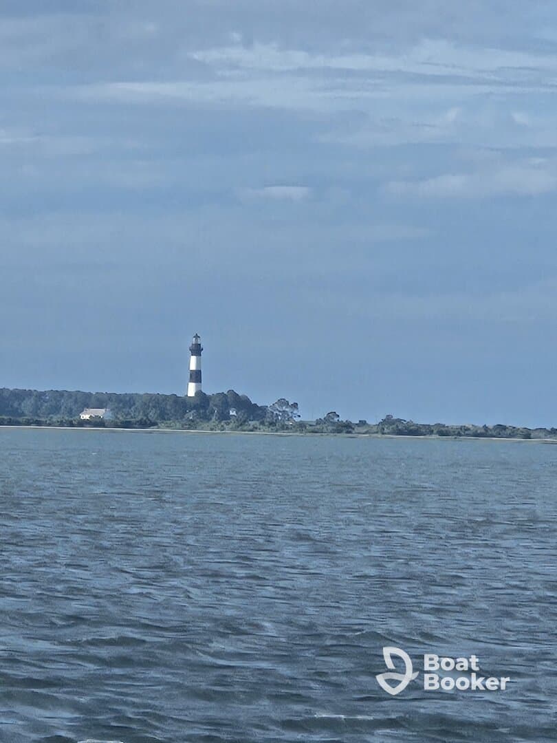 A picturesque view of a lighthouse standing tall against a serene backdrop of water and sky, perfect for capturing the essence of coastal adventures.