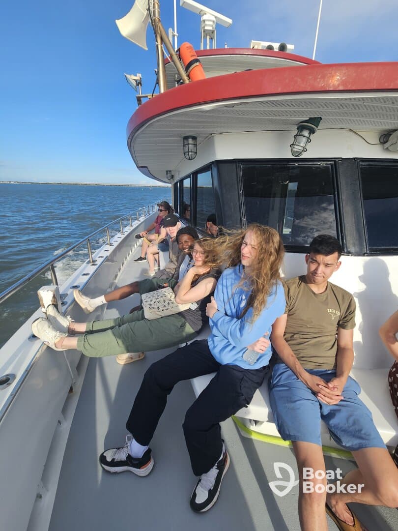 A group of friends relaxes on the deck of a boat, enjoying the ocean breeze and scenic views — perfect for a day out on the water.