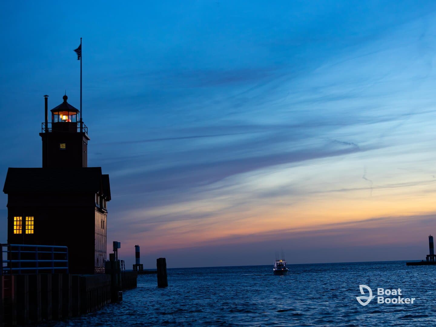 A picturesque sunset view featuring a lighthouse and a boat approaching the harbor, creating a serene maritime atmosphere.