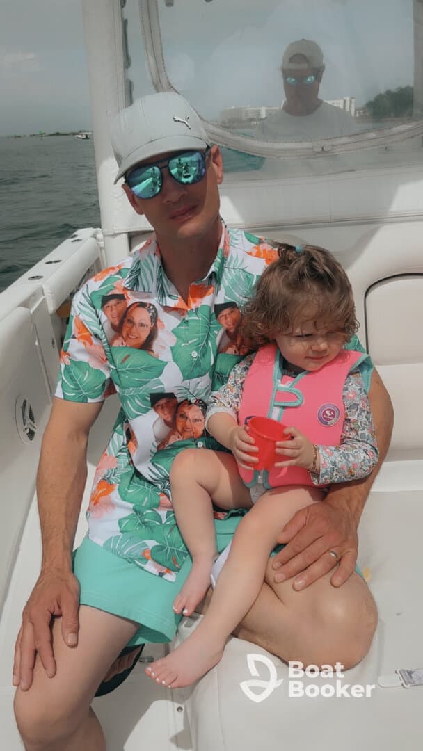 A father and his young daughter enjoy a sunny day on the boat, creating cherished family memories together.