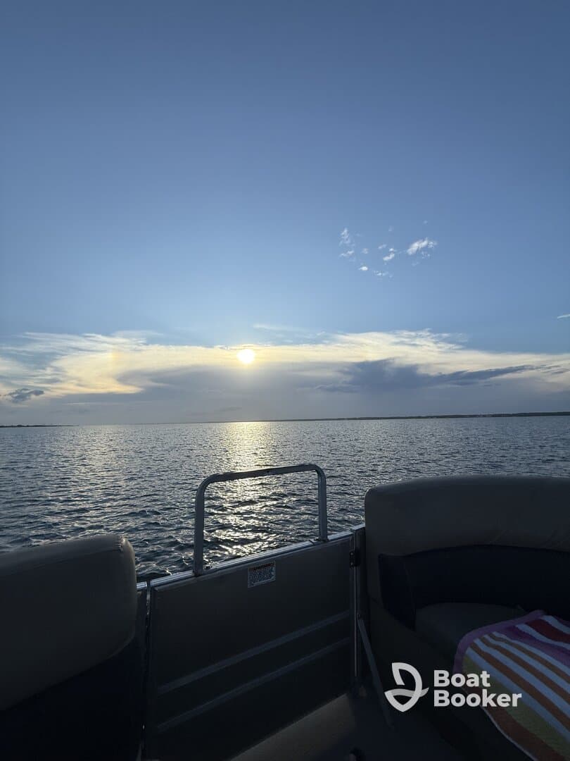 A serene sunset view from the deck of a boat, showcasing calm waters and a picturesque sky — perfect for evening cruises and relaxation on the water.