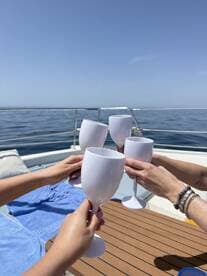 A group toasts with cocktails on a boat, celebrating under the sun — perfect for memorable gatherings and special occasions on the water.