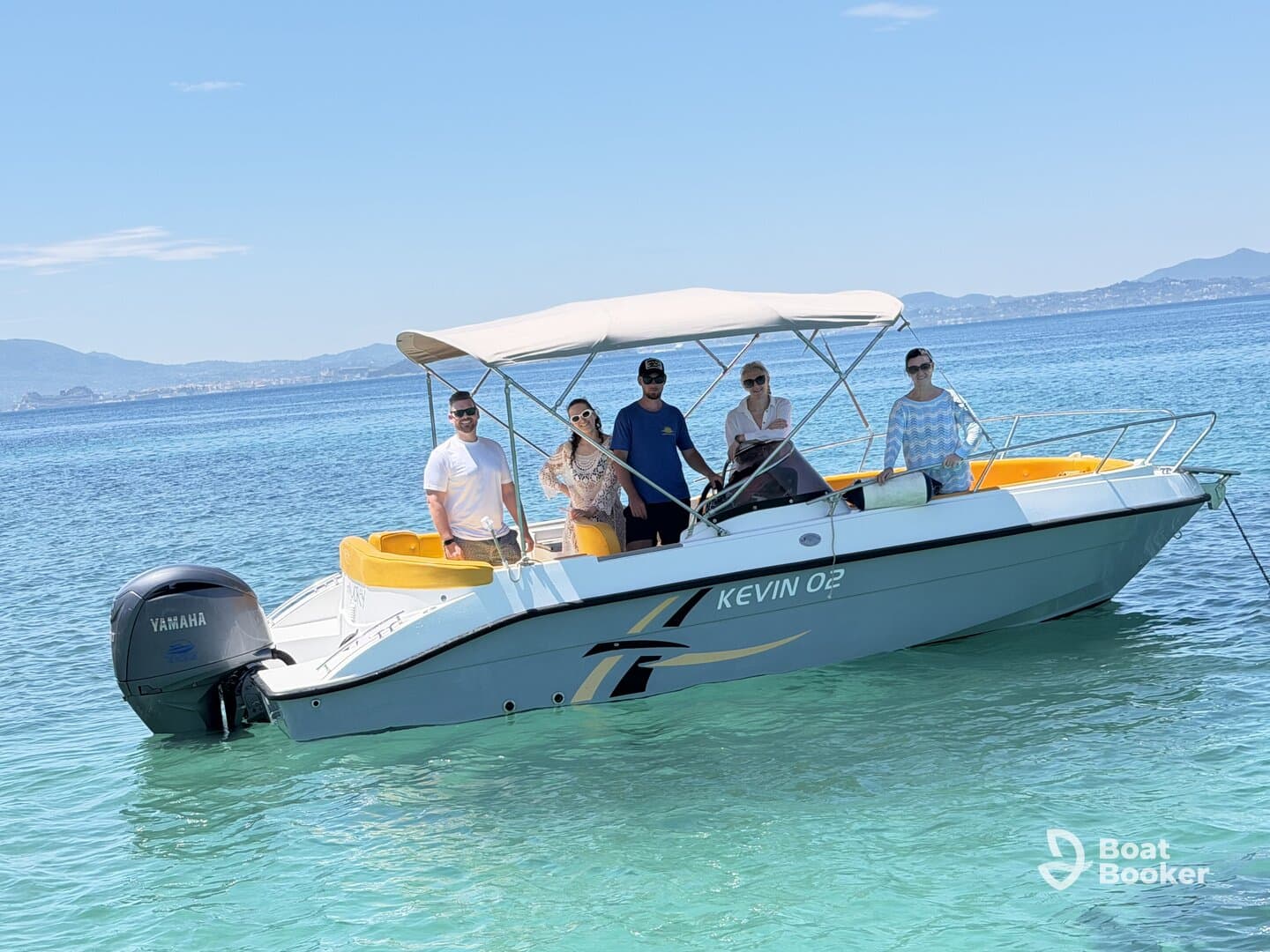 A cheerful group poses on a boat in clear turquoise waters, perfect for a fun day out on the ocean.