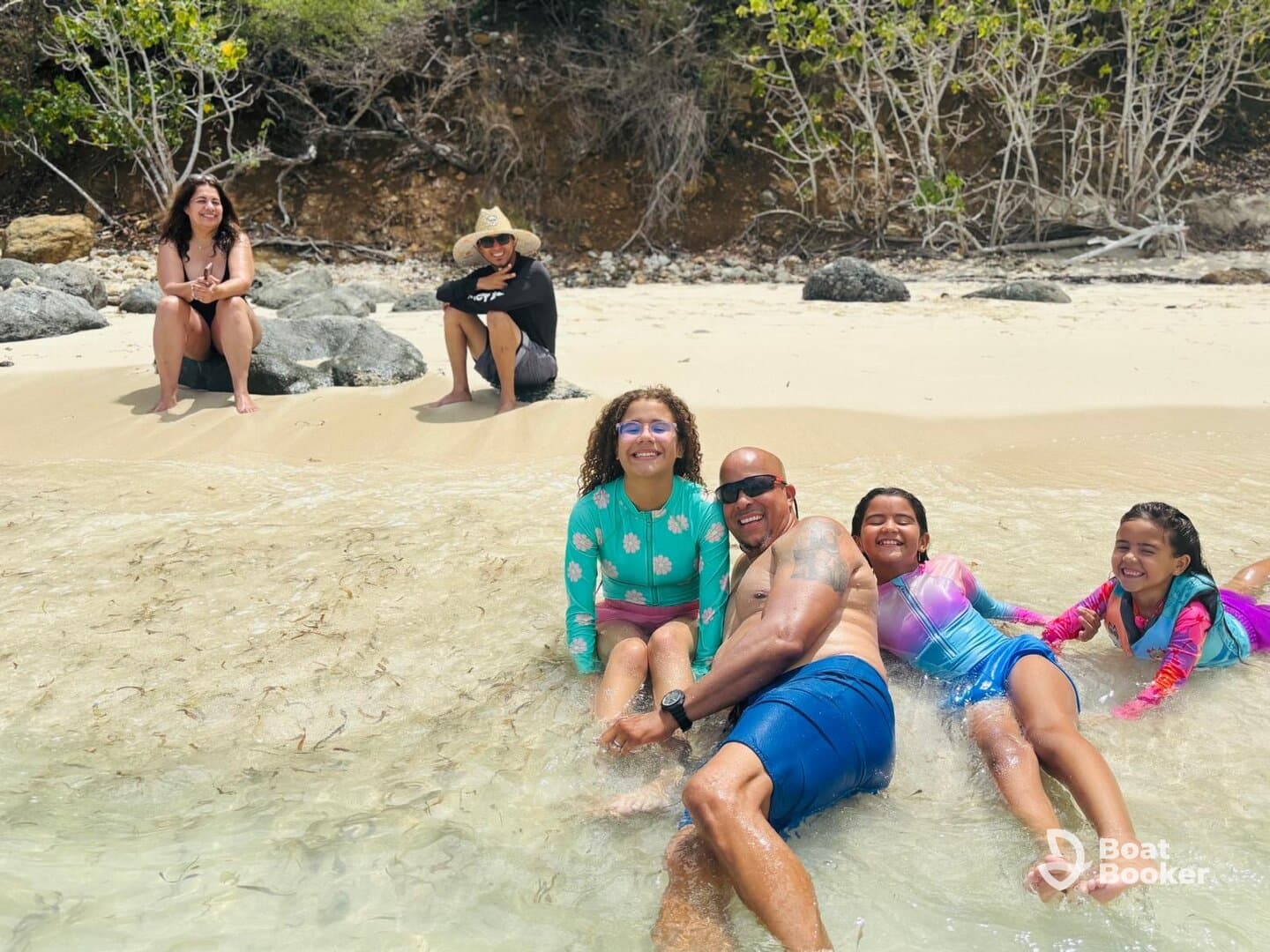 A joyful family enjoys a fun day at the beach, playing in the shallow water and creating lasting memories together.