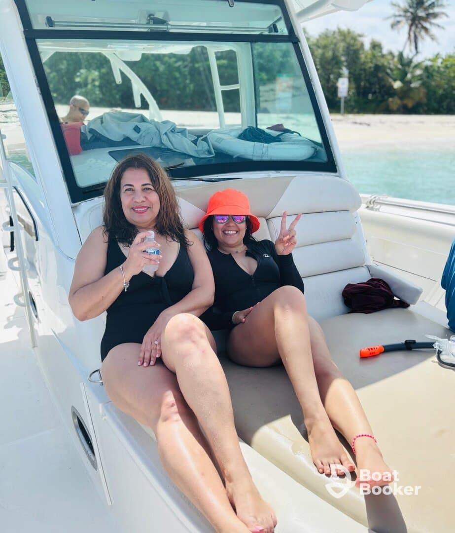 Two friends enjoy a sunny day on a boat, relaxing and celebrating with drinks — perfect for a fun day out on the water.
