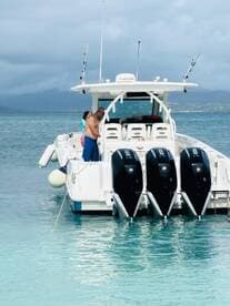 A group of people interacts on a boat in clear waters, showcasing a fun day on the water — perfect for family outings or adventure trips.