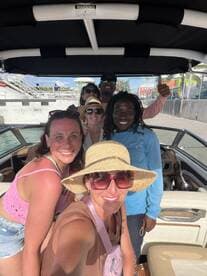 A cheerful group of friends poses for a selfie on a boat, capturing the excitement of their day on the water — perfect for memorable outings and adventures.