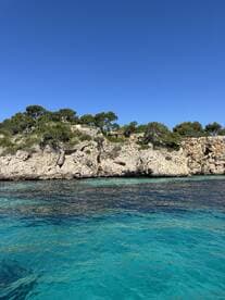A stunning view of a rocky coastline surrounded by crystal-clear turquoise waters, perfect for exploring the natural beauty of the area.