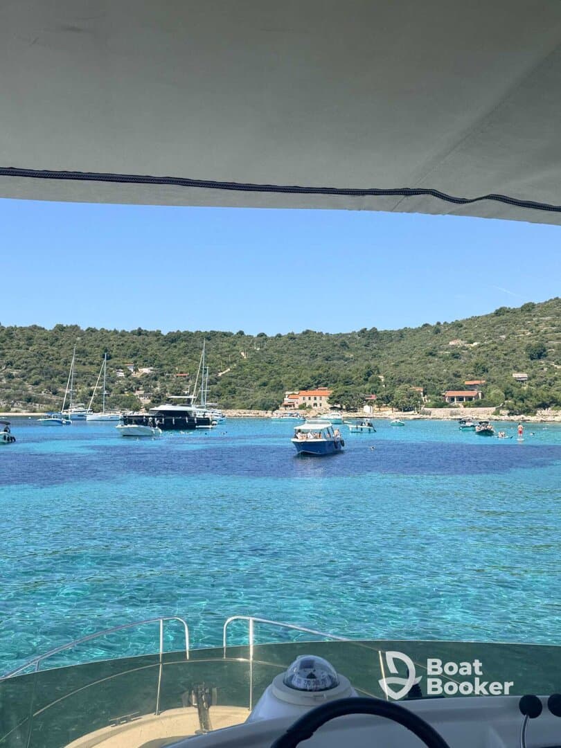 A picturesque view of a tranquil bay filled with boats and surrounded by lush greenery, showcasing the beauty of coastal adventures.