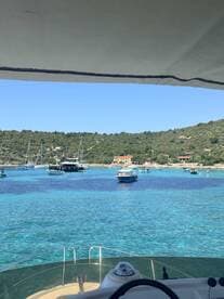 A picturesque view of a tranquil bay filled with boats and surrounded by lush greenery, showcasing the beauty of coastal adventures.
