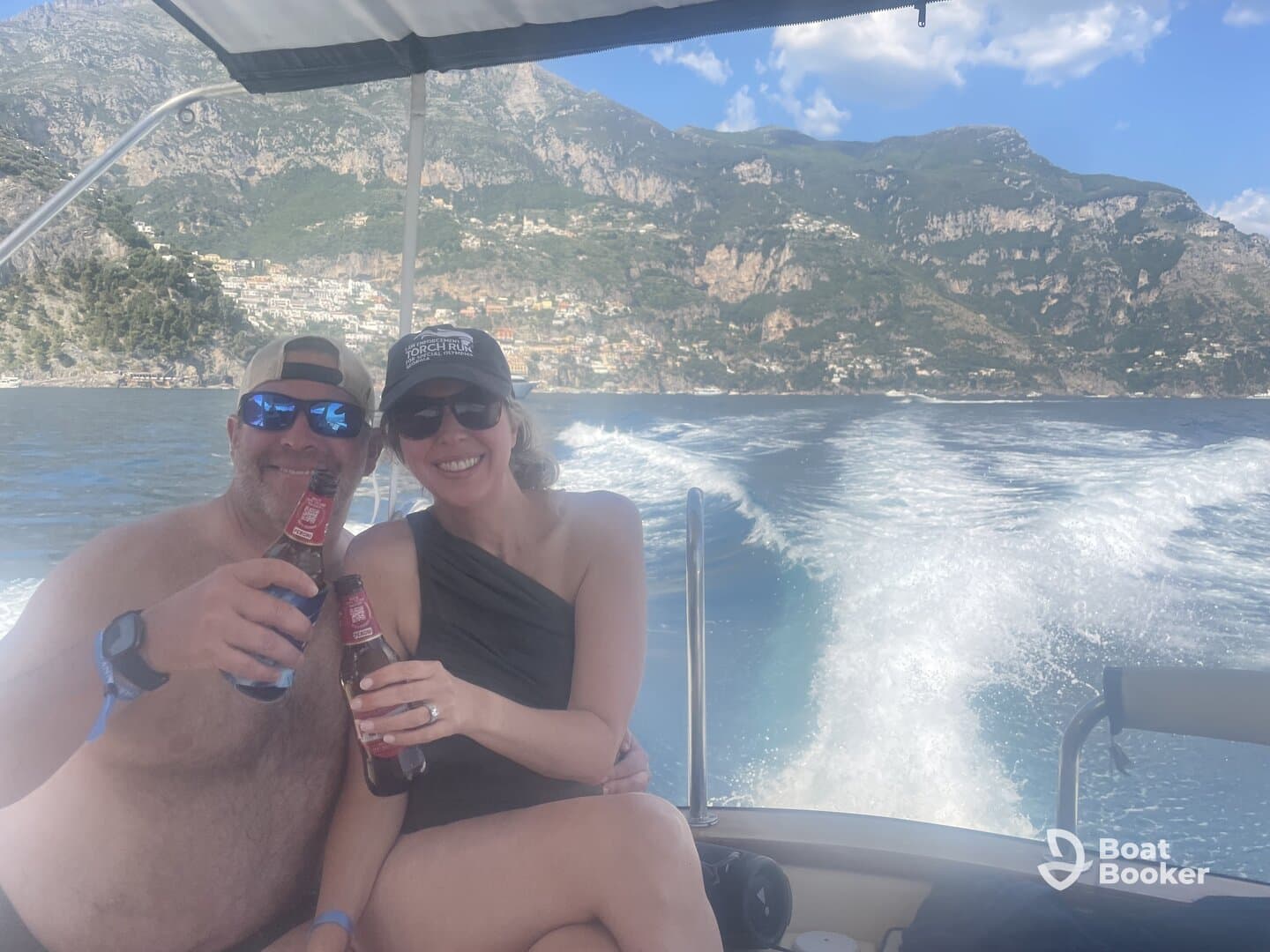 A couple enjoys drinks while cruising on a boat, surrounded by stunning coastal scenery — perfect for romantic getaways or fun outings on the water.