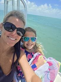 A joyful moment captured on a boat with a mother and daughter enjoying the ocean breeze, perfect for family outings and memorable adventures on the water.