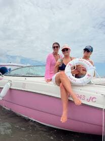 Three friends enjoy drinks aboard a stylish boat, celebrating their day on the water — perfect for summer outings and memorable adventures.