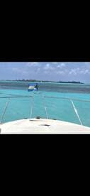 A stunning view from the bow of a boat, showcasing the vibrant turquoise waters and a distant island, perfect for exploring the beautiful Bahamas.