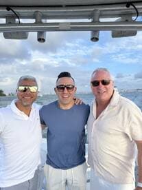 Three friends pose together on a boat, enjoying their time on the water — perfect for capturing memorable moments during a day out at sea.