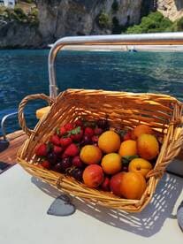A beautifully arranged basket of fresh fruits, including strawberries, peaches, and cherries, perfect for enjoying on a boat trip. Ideal for catering or snack provisions while cruising.