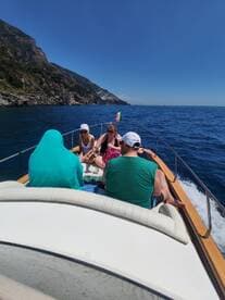A lively group enjoys a sunny boat ride along a stunning coastline, perfect for creating unforgettable memories on the water.