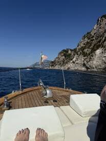 A serene view from the helm of a boat, showcasing comfortable seating and the stunning coastline in the background — perfect for leisurely cruises along the water.
