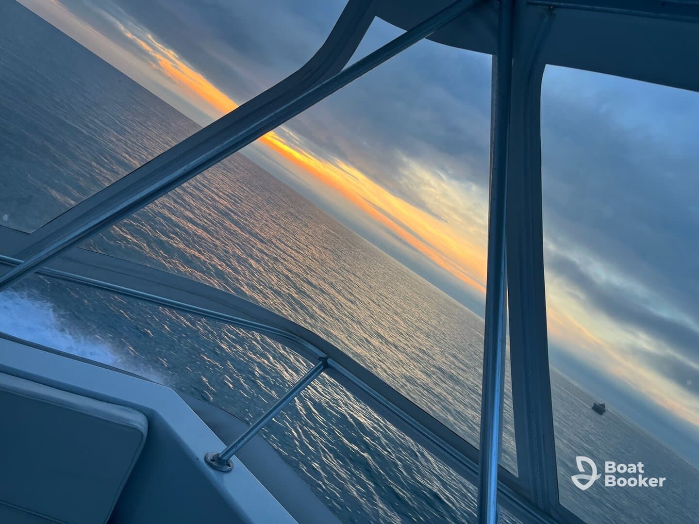 A stunning view from the helm of a boat, showcasing a vibrant sunset over calm waters — perfect for evening cruises.