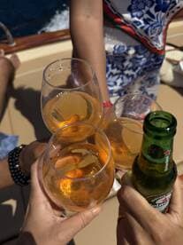 A joyful toast with cocktails and beer aboard a boat, capturing a moment of celebration among friends — perfect for memorable outings on the water.