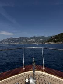 A stunning view from the front of a yacht, showcasing the serene blue waters and picturesque coastline, perfect for luxury boating experiences.
