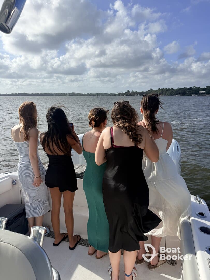 A group of friends enjoys a scenic view from the back of a boat, capturing memories on the water — perfect for celebrations and outings.