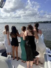 A group of friends enjoys a scenic view from the back of a boat, capturing memories on the water — perfect for celebrations and outings.
