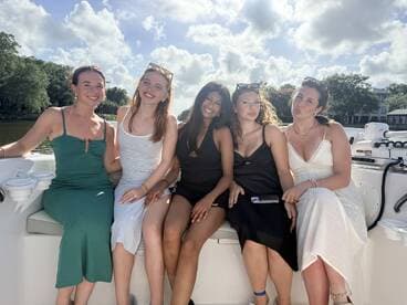A group of friends enjoys a sunny day on a boat, capturing joyful moments together — perfect for celebrations and memorable outings on the water.