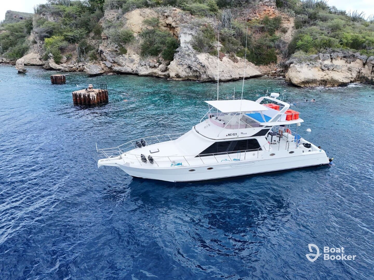 A stunning aerial view of a yacht cruising through crystal-clear waters, surrounded by rocky cliffs — perfect for exploring coastal destinations.