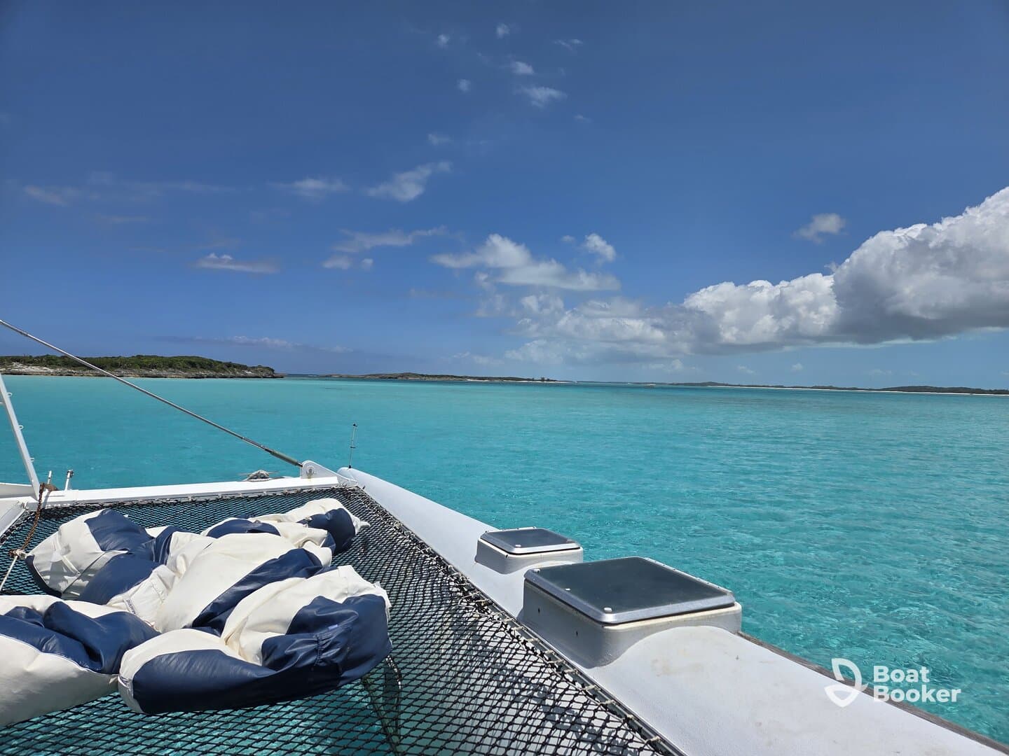 A serene view from the deck of a catamaran, showcasing the stunning turquoise waters and clear skies — perfect for a relaxing day on the water.