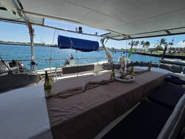 An inviting dining area inside a boat, featuring a long table set for guests with drinks and a scenic view of the water — perfect for onboard dining experiences.