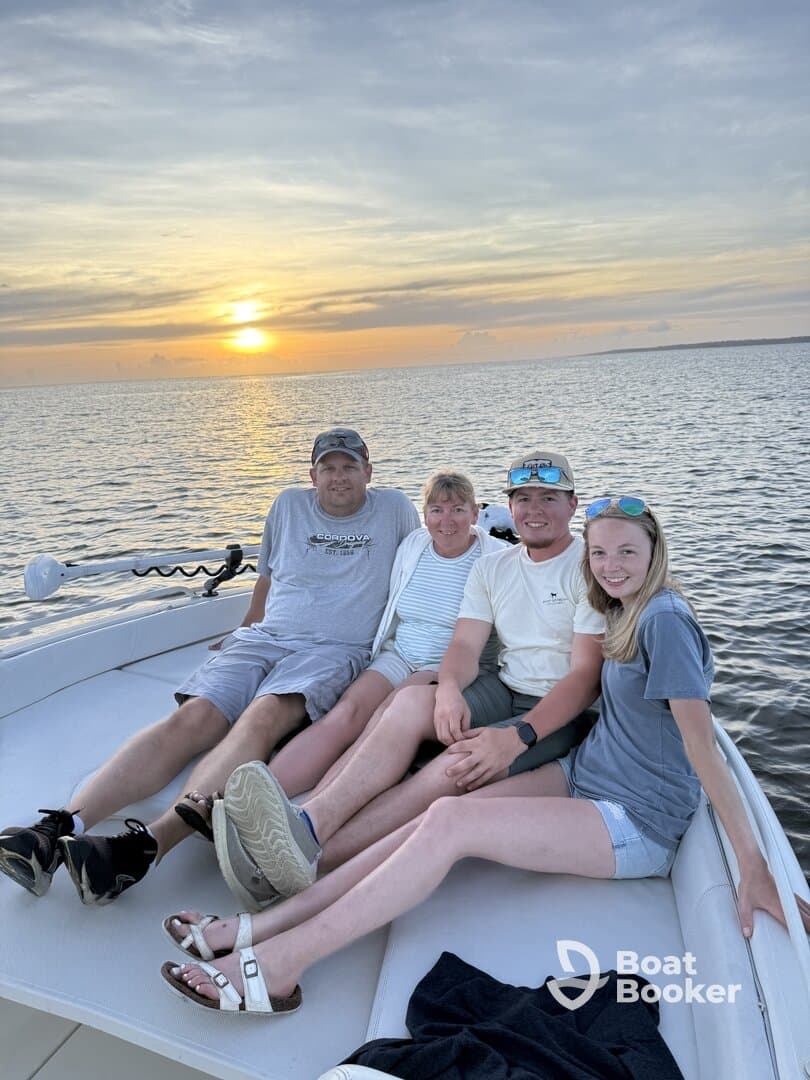A family enjoys a beautiful sunset together on a boat, capturing a memorable moment on the water.