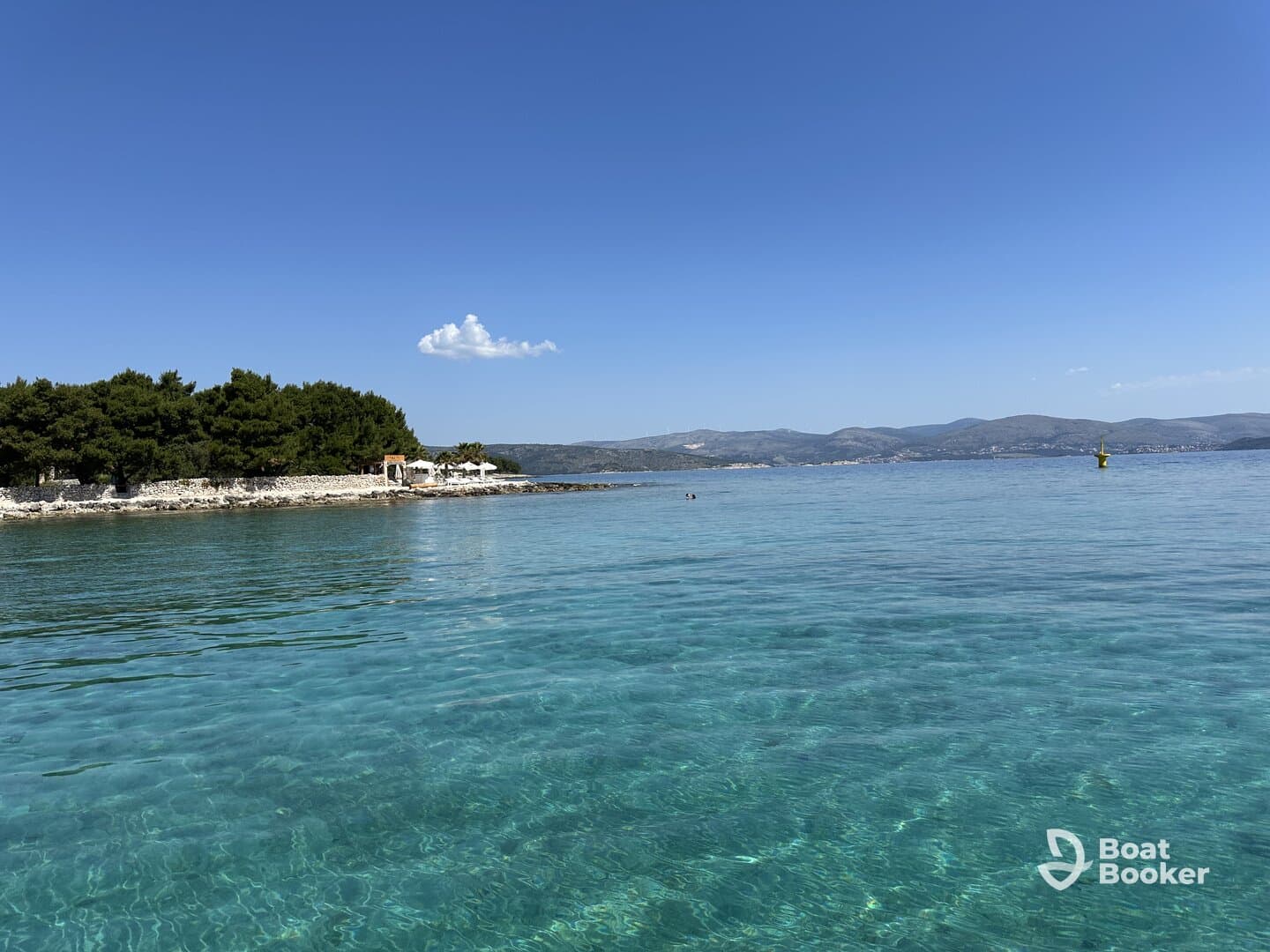 A stunning view of a serene coastline with crystal-clear waters, perfect for enjoying a day of relaxation and exploration on the water.
