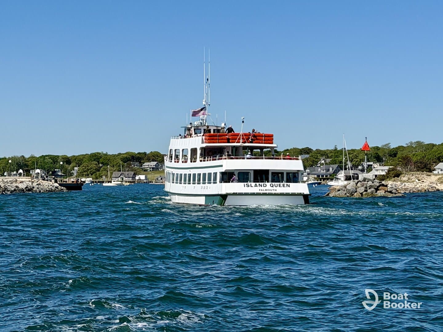 The Island Queen ferry navigates through the waters, showcasing its vibrant design against a picturesque coastal backdrop — perfect for scenic tours in Falmouth.