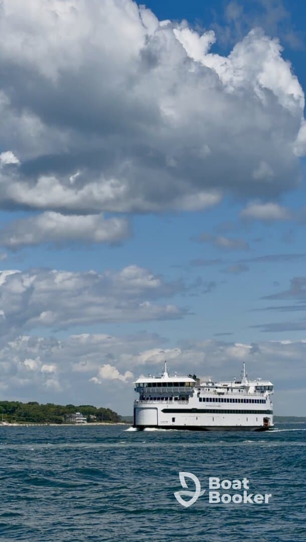 A ferry navigates through calm waters under a picturesque sky, showcasing the beauty of maritime travel.
