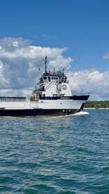 A striking view of the MONOMOY vessel cruising through clear waters, showcasing its robust design and maritime capabilities.