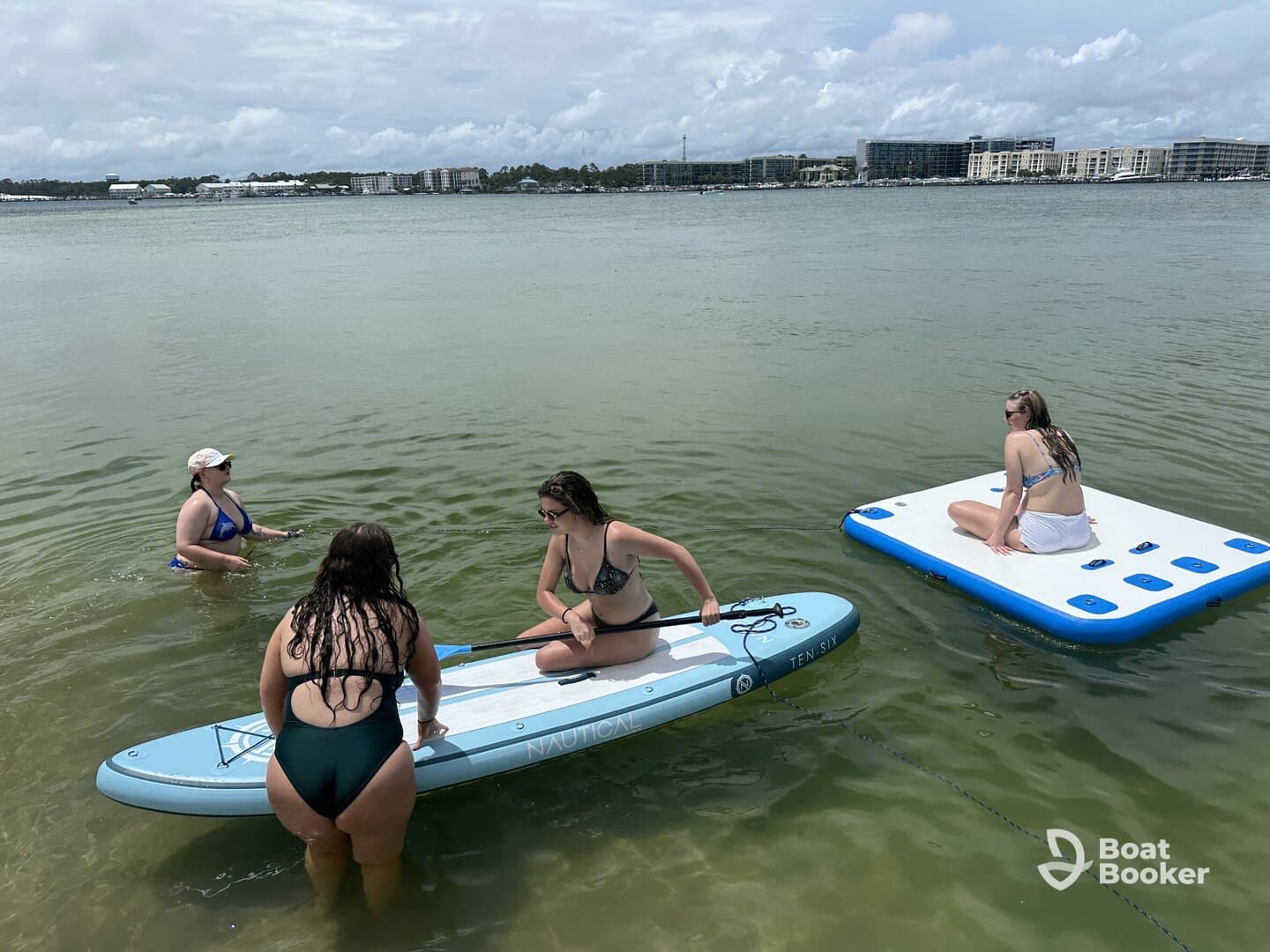 A fun day on the water with friends, featuring paddleboarding and relaxing on a floating mat — perfect for summer adventures.