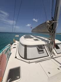 A close-up view of a catamaran's deck, showcasing its sleek design and the tranquil turquoise waters in the background, perfect for sailing adventures.