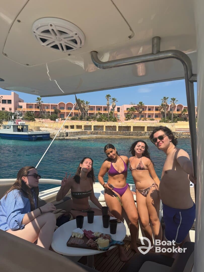 A lively group enjoys a boat party with drinks and a charcuterie spread, capturing the essence of fun and relaxation on the water.