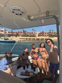 A lively group enjoys a boat party with drinks and a charcuterie spread, capturing the essence of fun and relaxation on the water.