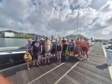 A cheerful group gathers at the dock, ready for a day of snorkeling and adventure on the water. Perfect for family outings or group excursions.