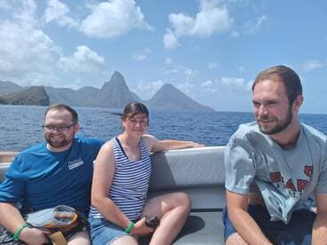 A cheerful group enjoys a boat ride with stunning mountain scenery in the background, capturing the essence of adventure on the water.