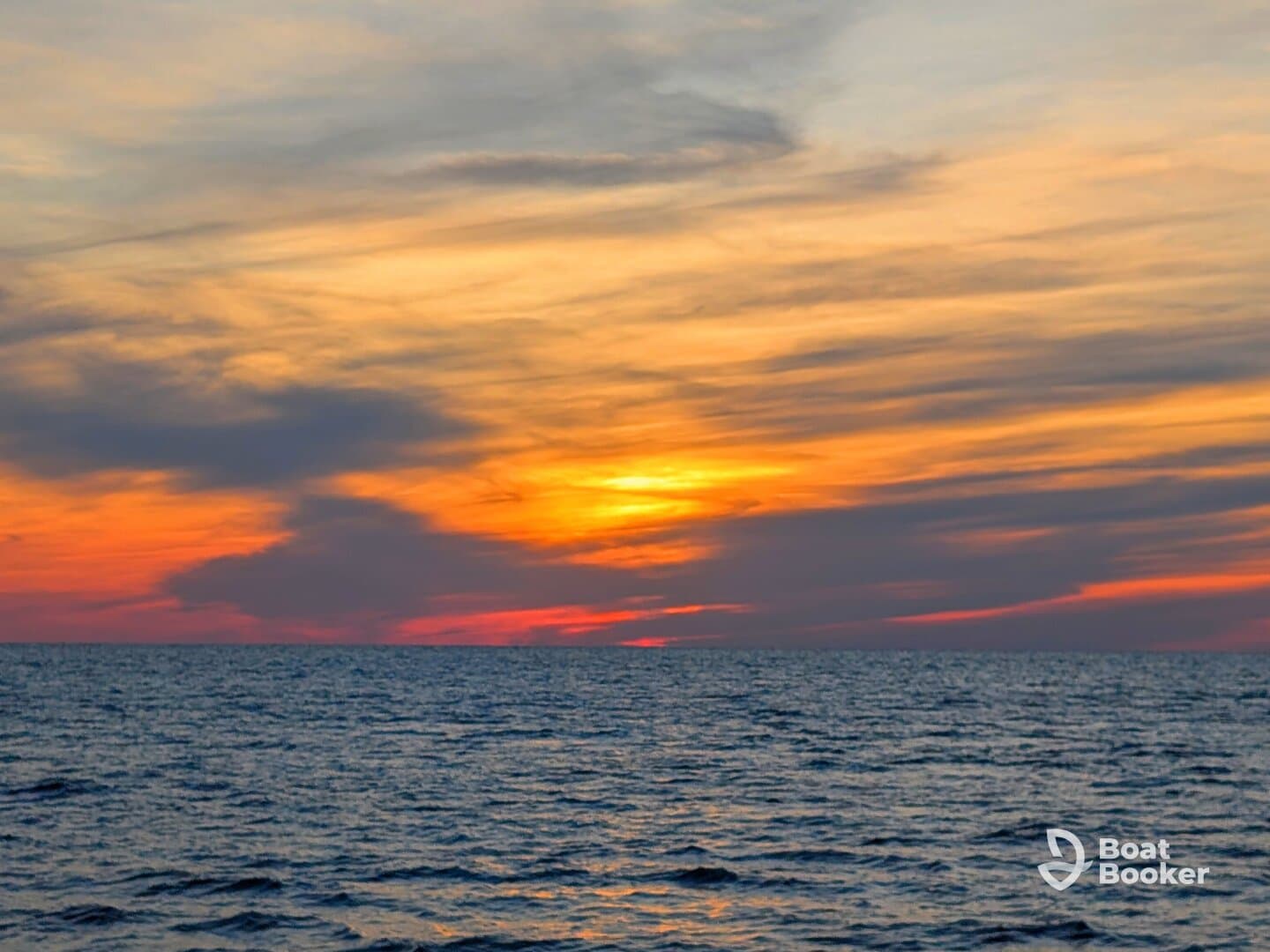 A stunning sunset over the ocean, showcasing vibrant colors that create a picturesque backdrop for any boating adventure.