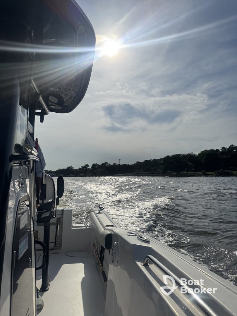 A scenic view from the side of a boat underway, capturing the sun's reflection on the water — perfect for showcasing boating adventures.